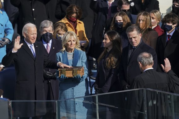 조 바이든 미국 대통령(왼쪽)이 20일(현지시간) 워싱턴DC 의회 의사당 앞에서 거행된 59회 대통령 취임식에서 존 로버츠 연방대법관(오른쪽) 앞에서 취임 선서를 하고 있다.AP뉴시스