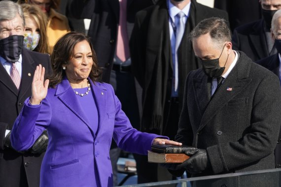 카멀라 해리스(왼쪽) 미국 부통령이 20일(이하 현지시간) 워싱턴 의사당 대통령 취임식장에서 부군 더그 엠호프가 들고 있는 성경에 손을 얹고 부통령 선서를 하고 있다. 사진=AP뉴시스