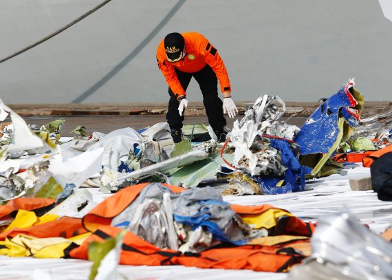 A member of Indonesia's rescue personnel observes the debris of Sriwijaya Air flight SJ 182, which crashed into the Java Sea, at the last day of the search and rescue operation, at Tanjung Priok port in Jakarta, Indonesia January 21, 2021. REUTERS/Ajeng Dinar Ulfiana /REUTERS/뉴스1 /사진=뉴스1 외신화상