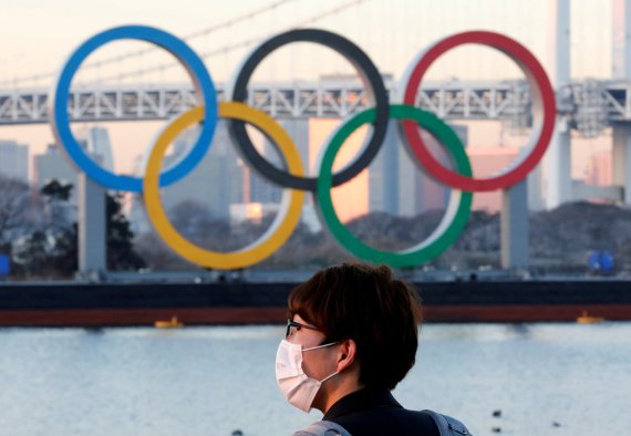 마스크를 쓴 한 남성이 도쿄에 설치된 대형 올림픽 마크 앞에 서 있다. 로이터 뉴스1