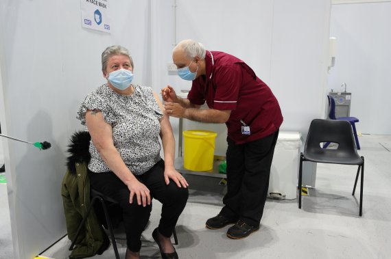 지난 25일(현지시간) 영국 블랙풀의 빅토리아 병원에서 퇴직 간호사인 로버트 워드(오른쪽)가 옥스퍼드대-아스트라제네카 코로나19 백신 접종을 하고 있다.로이터뉴스1