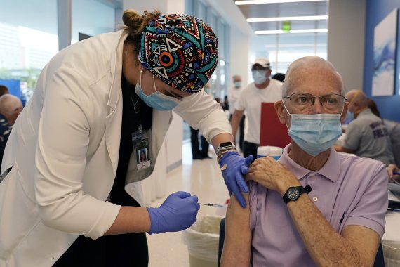 27일(현지시간) 미국 플로리다주 마이애미의 잭슨병원에서 한 시민이 화이자 코로나19 백신을 접종받고 있다.AP뉴시스