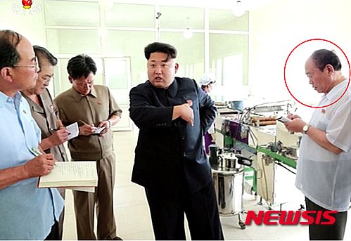 【서울=뉴시스】北 조선중앙TV는 11일 북한 김정은 국방위원회 제1위원장이 평양대경김가공공장을 현지지도했다고 보도하고 있다. 사진속 붉은 원은 노동당 39호실 실장으로 '김정은 금고지기' 전일춘으로 알려졌다.전일춘이 북한 매체에 등장한 것은 최근 39호실 간부들의 탈북설을 일축하고 건재를 과시하기 위한것으로 해석된다. 2015.07.011. (사진=조선중앙TV 캡쳐) photo@newsis.com