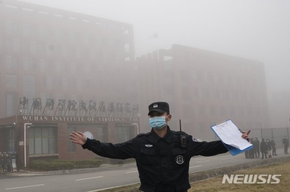지난 2021년 2월 3일 세계보건기구(WHO) 조사단이 중국 후베이성 우한의 바이러스 연구소를 방문했을 당시 한 보안요원이 취재진의 접근을 막고 있다. AP뉴시스