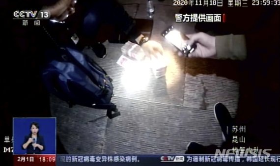 중국 CCTV가 촬영 영상에 지난해 11월 18일 중국 공안이 중국 장쑤성 쿤산에서 가짜 코로나19 백신 판매 대금을 압수하고 있다. 뉴시스 제공