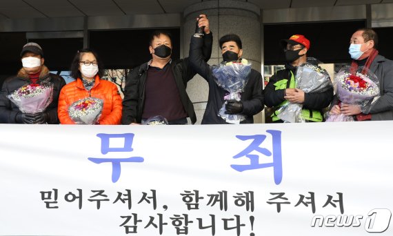 ‘낙동강변 살인사건’ 범인으로 지목돼 21년간 옥살이를 한 장동익씨와 최인철씨가 4일 오전 부산 연제구 부산고등법원에서 열린 재심 선고 공판을 마친 후 손을 들어 보이고 있다. 2021.2.4/뉴스1 © News1 여주연 기자