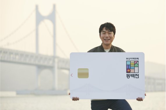 부산 출신 배우 이시언씨가 부산 광안대교 앞에서 동백전을 알리고 있다. 부산시 제공