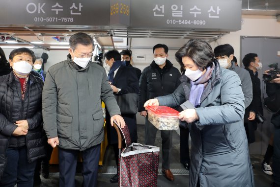 [인천=뉴시스]박영태 기자 = 문재인 대통령과 부인 김정숙 여사가 10일 오전 인천시 남동구 소래포구 전통어시장을 방문, 구입한 해산물을 용기에 담아 장바구니 카트에 넣고 있다. 문 대통령 내외는 1회용 용기 사용 자제를 위해 상품을 담을 용기를 지참했다. 2021.02.10. since1999@newsis.com <저작권자ⓒ 공감언론 뉴시스통신사. 무단전재-재배포 금지.> /사진=뉴시스화상