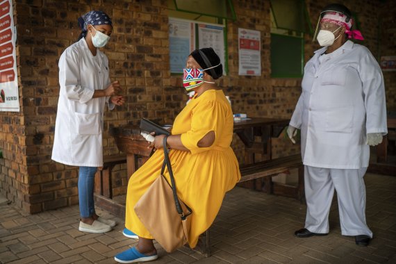 남아프리카공화국 요하네스버그에서 지난달 11일(현지시간) 한 여성이 코로나19 검사 전 설명을 듣고 있다. 중국·남아공 경찰은 3일 대규모 짝퉁 코로나19 백신 조직을 검거했다. 사진=AP뉴시스