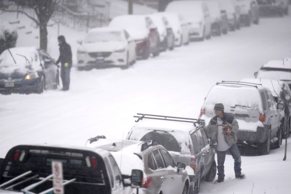 미국 미주리주 세인트루이스에서 15일(현지시간) 주민들이 차에서 눈을 털어내고 있다. 이날 겨울 폭풍으로 인해 포드와 제너럴모터스(GM)의 미주리주 공장이 문을 닫았으며 미 기상청은 최소 5000만명의 미국인이 영하 17.7도 이하의 맹추위를 견뎌야 한다고 경고했다. AP뉴시스