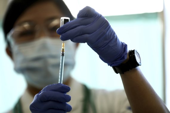 도쿄의 한 의료기관에 종사중인 한 의료진이 화이자 코로나19 백신을 주사기에 주입하고 있다. AP뉴시스