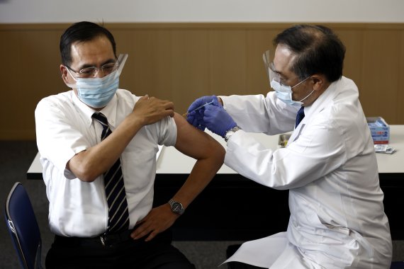 일본에서 코로나19 백신 접종이 시작된 17일 첫 접종자인 아라키 가즈히로 도쿄의료센터 원장이 화이자 백신을 맞고 있다. AP뉴시스