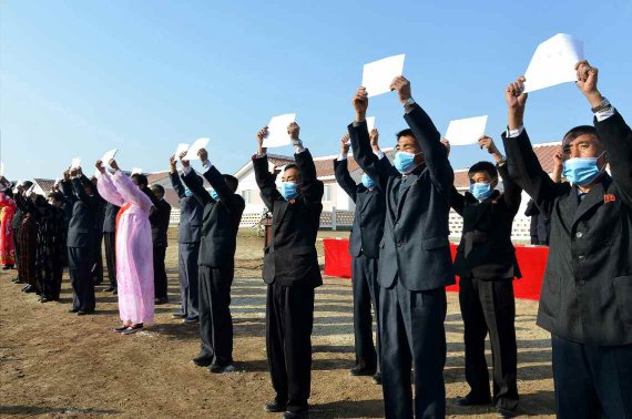 (평양 노동신문=뉴스1) = 수해복구를 마치고 살림집을 받은 주민들이 입사증을 들고 서 있다. [국내에서만 사용가능. 재배포 금지. DB 금지. For Use Only in the Republic of Korea. Redistribution Prohibited] rodongphoto@news1.kr