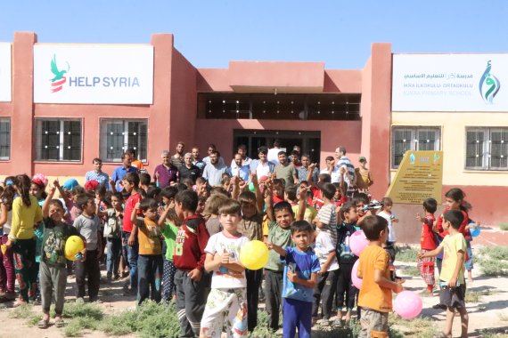 지난 2019년 8월 시리아 알레포에 건립된 '이끄라 초등학교'앞에서 공사에 참여한 단체 관계자들과 학교 학생들이 모여있다.(헬프시리아 제공) © 뉴스1