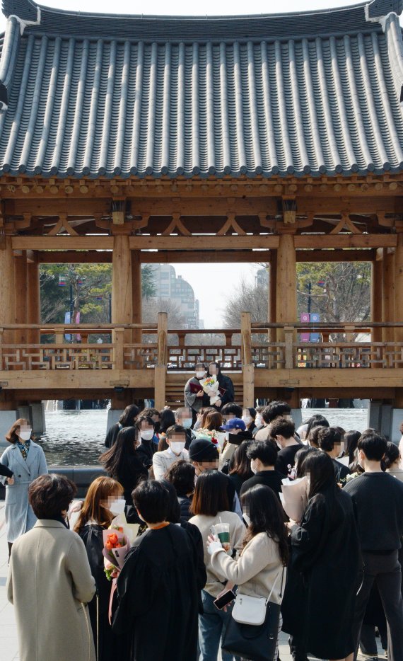 [전주=뉴시스] 김얼 기자 = 전국적으로 대학교의 졸업식이 이어지고 있는 22일 전북 전주시 전북대학교에서 학생들이 사회적 거리두기를 지키지 않고 사진을 찍고 있다. 2021.02.22.pmkeul@newsis.com