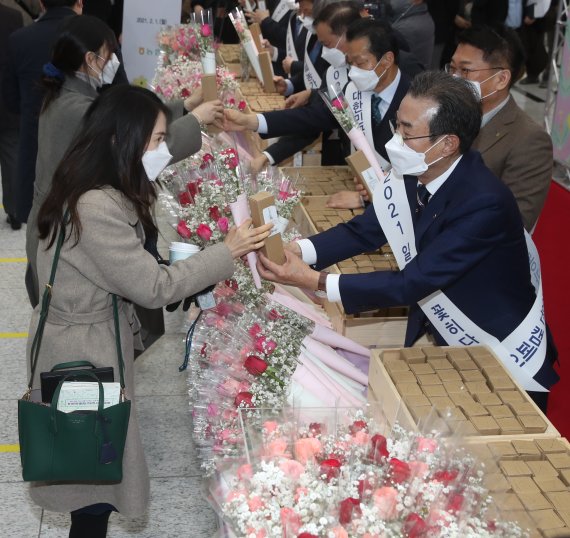 지난 1일 서울시 중구 농협중앙회 본관에서 열린 범농협 임직원 꽃 나눔행사에서 이성희 농협중앙회장(오른쪽)이 꽃을 나눠주고 있다. 농협 제공