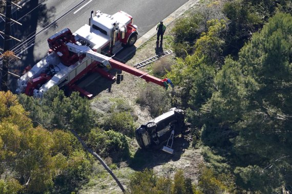 지난달 23일(현지시간) 미국 캘리포니아주 LA카운티에서 현지 교통 당국이 타이거 우즈의 사고 차량을 정리하고 있다.AP뉴시스