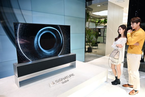 LG전자 모델들이 매장 입구에 마련된 롤러블 TV 전시존에서 세계 최초 롤러블 올레드 TV인 LG 시그니처 올레드 R를 소개하고 있다.