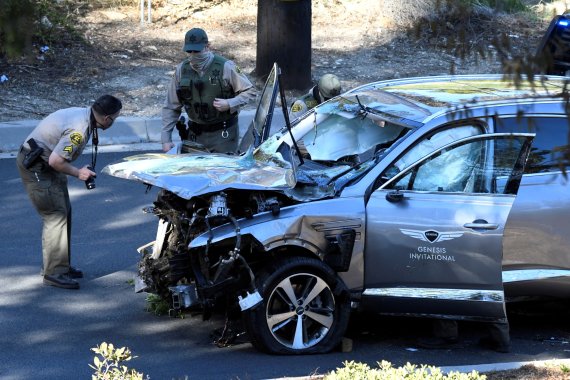 미국 캘리포니아주 로스앤젤레스카운티에서 23일(현지시간) 보안관들이 이날 전복된 미 프로 골퍼 타이거 우즈의 사고 차량을 살펴보고 있다.로이터뉴스1