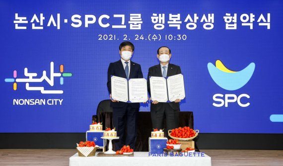 황재복 SPC 대표이사(오른쪽)와 황명선 논산시장이 24일 논산시청에서 열린 ‘논산시-SPC그룹 행복상생 업무협약식’에서 기념촬영을 하고 있다.