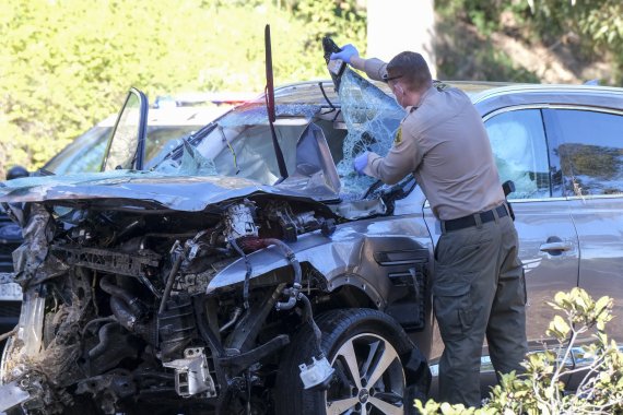 '골프 황제' 타이거 우즈가 23일(현지시간) 차량 전복 사고를 당해 긴급수술을 받았다. 우즈가 타고 있던 제네시스 GV80 차량을 한 경찰관이 살펴보고 있다. AP뉴시스