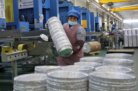 지난 2월22일 중국 안후이성 수이시의 알루미늄 공장 직원이 제작된 알루미늄 식기를 쌓고 있다.AP뉴시스