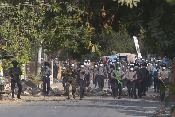 미얀마 군경이 지난 달 28일(현지시간) 미얀마 제2의 도시 만달레이에서 반쿠데타 시위대를 진압하기 위해 봉쇄선을 넘고 있다. 이날 군경의 무력 진압으로 최소 18명의 시위대가 사망하고 수십명이 다쳤다. 뉴시스 제공