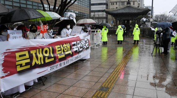 3·1절인 1일 일부 보수 시민단체들이 서울 광화문 등 주요 도심지에서 정부 규탄 집회, 기자회견, 차량 시위 등을 열었다. 코로나19 확산을 우려해 법원이 참석 인원을 9명 이하로 제한하고 비가 쏟아지면서 대규모 시위로 번지지는 않았다. 서울 종로 교보빌딩 앞에서 경찰의 출입 통제 아래, 여성단체 주최의 '문재인 탄핵 특검' 기자회견이 진행되고 있다. 사진=박범준 기자