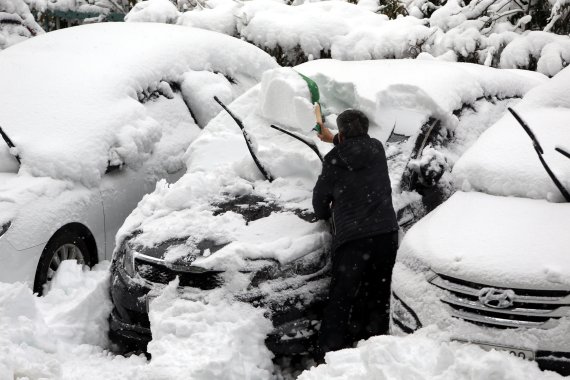 2일 오전 대설경보가 내려진 강원도 강릉에 눈이 펑펑 쏟아지는 가운데 운전자가 출근하기 위해 차에 가득 쌓인 눈을 치워내고 있다. /사진=뉴시스화상