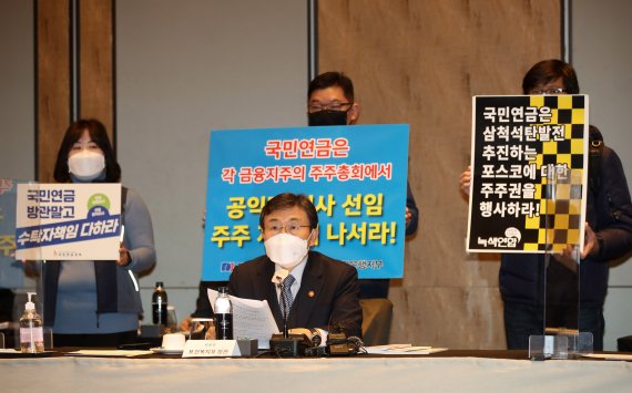 [서울=뉴시스]고범준 기자 = 권덕철 보건복지부 장관이 24일 오후 서울 종로구 포시즌스 호텔 그랜드볼룸에서 열린 제2차 국민연금기금운용위원회에 참석해 발언을 하고 있다. 이번 회의에서 전국금융산업노동조합 KB국민은행지부, 민주노총 전국공공운수노동조합 국민연금지부, 녹색연합 등 시민단체가 국민연금 주주권 행사를 촉구하며 피켓팅을 하고 있다. 2021.02.24. bjko@newsis.com