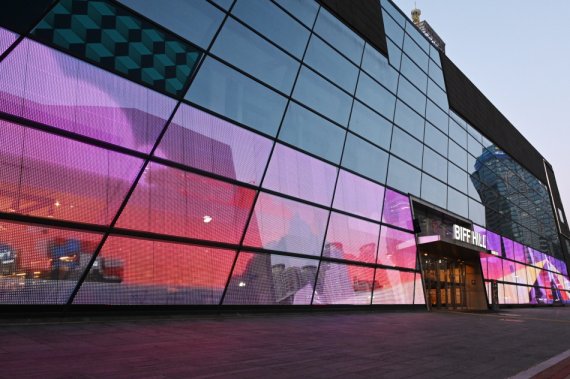 [서울=뉴시스] LG전자가 부산 해운대구 소재 영화의전당 유리벽에 206제곱미터 규모 투명 LED 필름을 설치했다고 3일 밝혔다. 투명 LED 필름이 설치된 영화의전당 외벽은 낮에는 투명한 일반 유리창처럼 보이지만, 저녁에는 영화 명장면을 보여주는 스크린이 된다. 사진은 투명 LED 필름이 설치된 영화의전당 주변 경관 모습 (제공=LG전자)