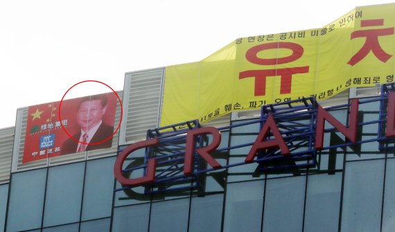 3일 오전 제주시 노형동 드림타워 복합리조트 38층 옥상에 시진핑 중국 국가주석 사진과 유치권 행사 현수막이 걸려있다.2021.3.3/뉴스1© News1