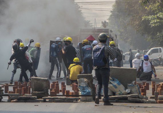 지난 3일 미얀마 만달레이에서 군부 쿠데타 반대 시위대가 임시 구조물을 방패 삼아 경찰이 발사한 최루탄에 맞서고 있다. 뉴시스 제공