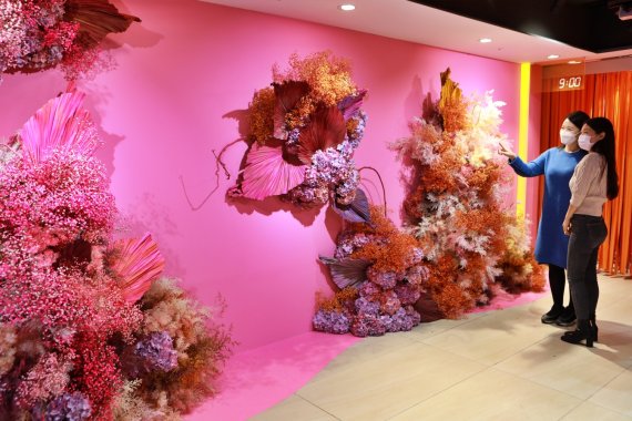 롯데백화점 본점에서 열린 '판타지 드림' 전시를 고객들이 감상하고 있다. '판타지 드림'은 다채로운 컬러의 꽃을 사용한 공간 연출을 통해 희망과 격려, 긍정의 메시지를 전달한다.