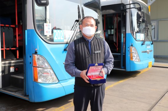 불이 난 상가를 보자마자 운전대를 놓고 불길로 뛰어든 버스기사 김상남씨(55)가 8일 오후 감사패를 받고 기념사진을 촬영하고 있다.2021.3.8/뉴스1© News1
