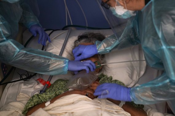 지난 1월7일(현지시간) 미국 캘리포니아주 오렌지카운티의 한 병원에서 간호사들이 코로나19 환자에게 인공호흡기를 씌우고 있다. 뉴시스