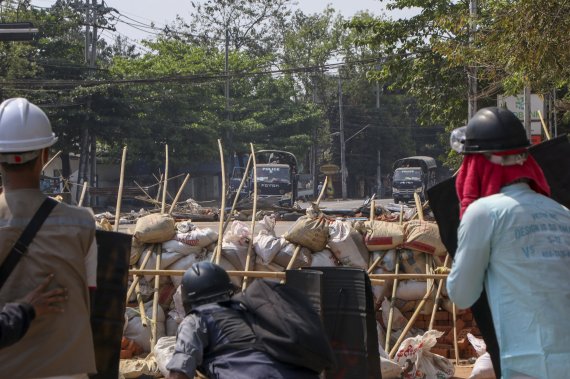 11일 미얀마 최대 도시 양곤에서 쿠데타 군부에 저항하는 민주화 시위대가 급조한 바리케이트 뒤에서 군경과 대치하고 있다.AP뉴시스