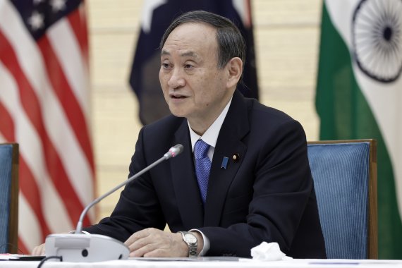 지난 12일 밤 일본 도쿄 총리 관저에서 스가 요시히데(오른쪽) 총리가 화상 형식으로 열린 미국·일본·호주·인도의 대중 안보 연합체 '쿼드(Quad)' 첫 정상회의를 가지고 발언하고 있다. AP뉴시스