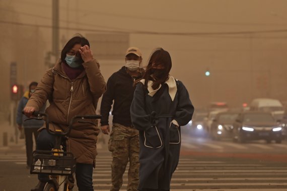 지난 15일 중국 베이징에서 마스크를 쓴 시민들이 공기 오염과 황사로 뿌연 거리를 지나고 있다. 중국 기상대는 베이징과 북부 지역에서 발생한 심각한 황사로 올해 첫 황사 경보를 발령했다. / 사진=AP뉴시스