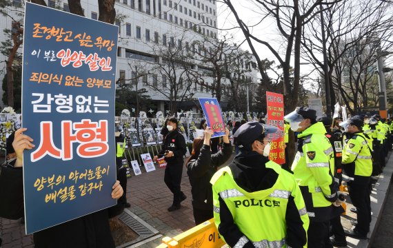 양부모 학대로 숨진 '정인이 사건' 4차 공판이 열린 17일 오후 서울 양천구 남부지방법원 앞에서 시민들이 손팻말을 들고 양부모에 대한 강력한 처벌을 촉구하고 있다. 뉴스1