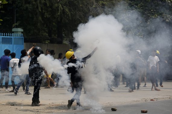 군사 쿠데타에 반대하는 미얀마 시민들이 27일(현지시간) 만달레이에서 시위대에 날아온 최루탄을 다시 경찰을 향해 던지고 있다. 이날 시위로 최소 91명이 사망한 것으로 집계됐다. 사진=AP뉴시스