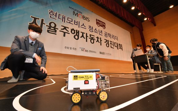 지난 27일 서울 하나고등학교에서 열린 ‘청소년 공학 리더 자율주행차 경진대회’에 참여한 청소년 공학 리더들이 직접 코딩한 자율주행차로 경기를 펼치고 있다. 현대모비스 제공