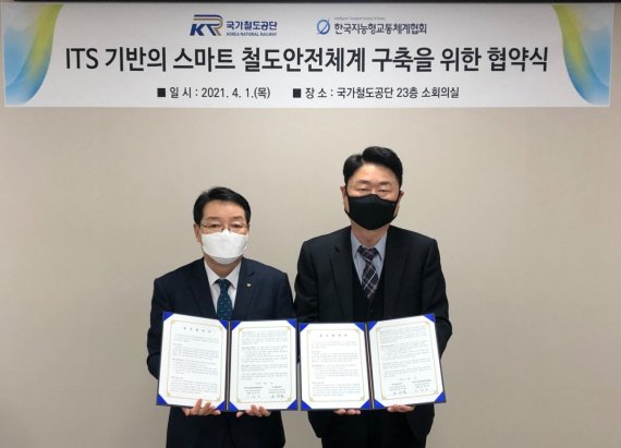 윤여철 국가철도공단 기획본부장(왼쪽)이 1일 김창연 한국지능형교통체계협회 부회장과 'ITS 기반의 스마트 철도안전체계 구축을 위한 협약'을 맺은 뒤 협약서를 들어보이고 있다.