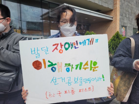 [서울=뉴시스]정유선 기자 = 2일 서울 종로구 종로장애인복지관 앞에서 열린 기자회견에서 한 장애인활동가가 피켓을 들고있다. 2021.4.2. *재판매 및 DB 금지