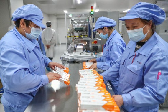 지난 1월6일 중국 베이징 소재 시노백 연구개발 플랜트에서 직원들이 신종 코로나바이러스 감염증(코로나19) 백신을 다루고 있다. 신화뉴시스
