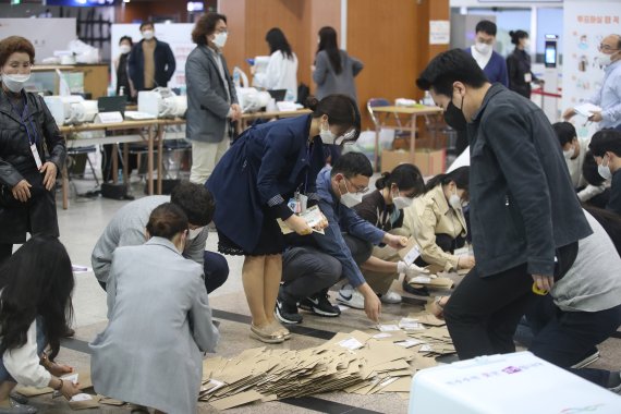 (서울=뉴스1) 임세영 기자 = 4·7 재·보궐선거 사전투표가 끝난 3일 오후 서울역 설치된 남영동 사전투표소에서 관계자들이 투표함을 열어 관외 투표용지 봉투를 확인하고 있다. 2021.4.3/뉴스1 /사진=뉴스1화상