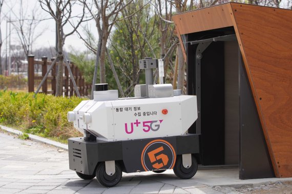 5G 자율주행로봇이 4일 전주시 전주방송공원 앞에 설치된 스테이션에서 무인순찰을 시작하기 위해 나오고 있다. 이 로봇은 24시간 대기질을 측정하고 오염물질 배출을 감시할 수 있다. LG유플러스 제공