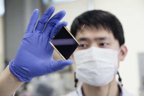 UNIST 김진영 교수팀의 연구진이 새롭게 개발한 페로브스카이트 태양전지를 들고 있다. UNIST 제공