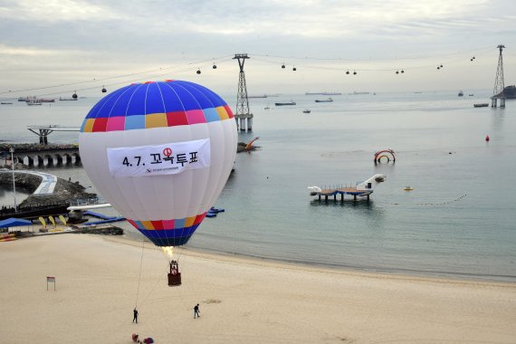 부산시장 보궐선거를 하루 앞둔 6일 오전 부산 서구 송도해수욕장에서 부산시선관위 직원 등이 '4·7 꼬옥 투표'라는 내용의 현수막이 부착된 열기구를 띄우며 투표참여를 홍보하고 있다. /사진=뉴시스