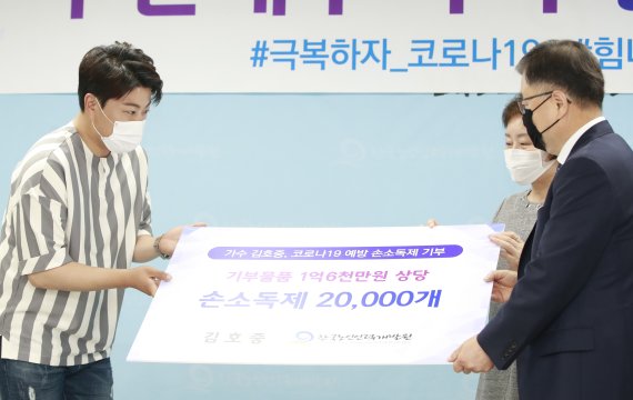 ‘미스터트롯’ 김호중(왼쪽)이 18일 경기도 일산동구 한국노인인력개발원에서 열린 코로나19 감염병 예방을 위한 ‘손 소독제 기부물품 전달식’에 참석해 강익구 한국노인인력개발원 원장, 김해인 고양시니어틀럽 대표(가운데)에게 기부금을 전달하고 있다. 2020.6.18./뉴스1 © News1 권현진 기자